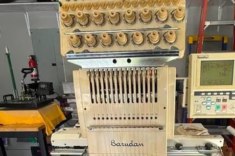 Single-head Barudan embroidery machine with its control panel beside the sewing head