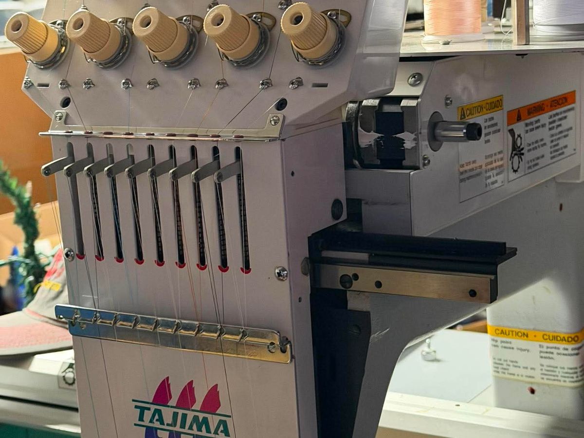 Close view of a Tajima sewing head with thread running down to each needle