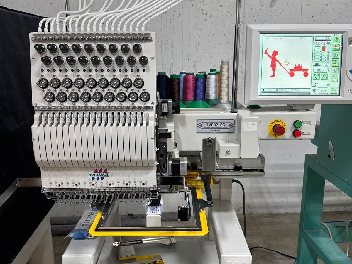 Tajima TMBR2-SC single-head on its white stand with spare clamp frames on the shelf