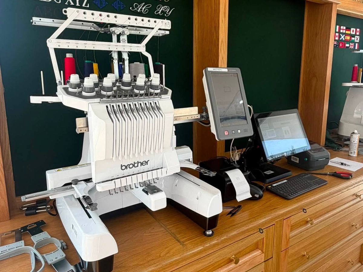 Brother ten-needle machine on an oak counter with hoops at the left