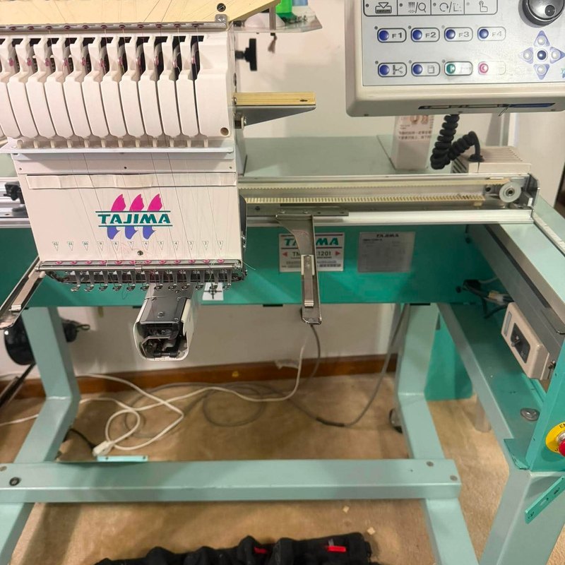 Tajima head, control panel, and X-axis rail on a teal stand