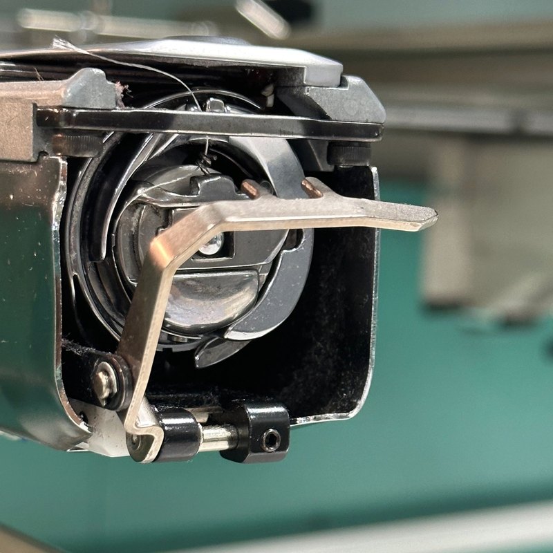 Close view of a rotary hook assembly under the needle plate