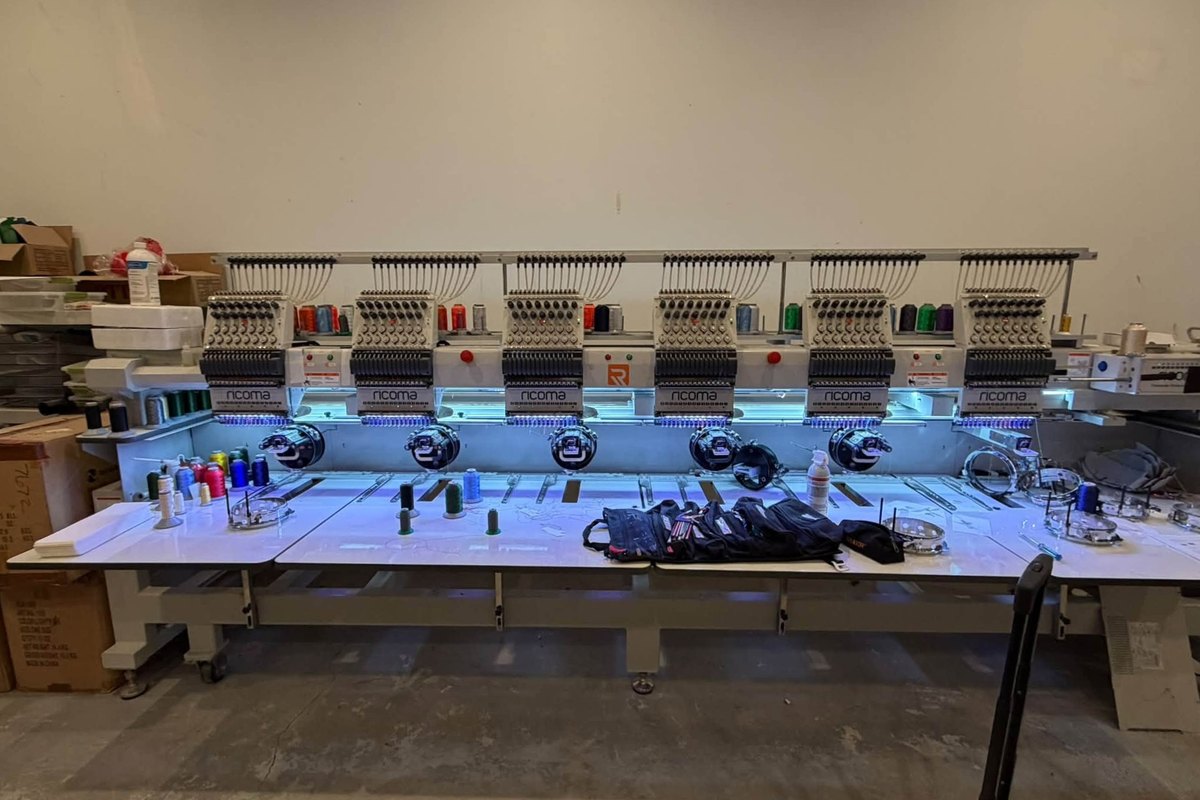 Six-head Ricoma embroidery machine with a technician's tool rolls on the table