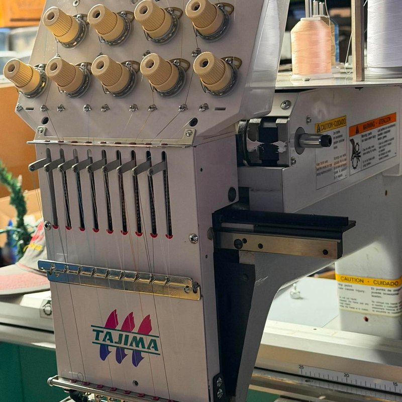 Front of a Tajima sewing head with thread running through each needle
