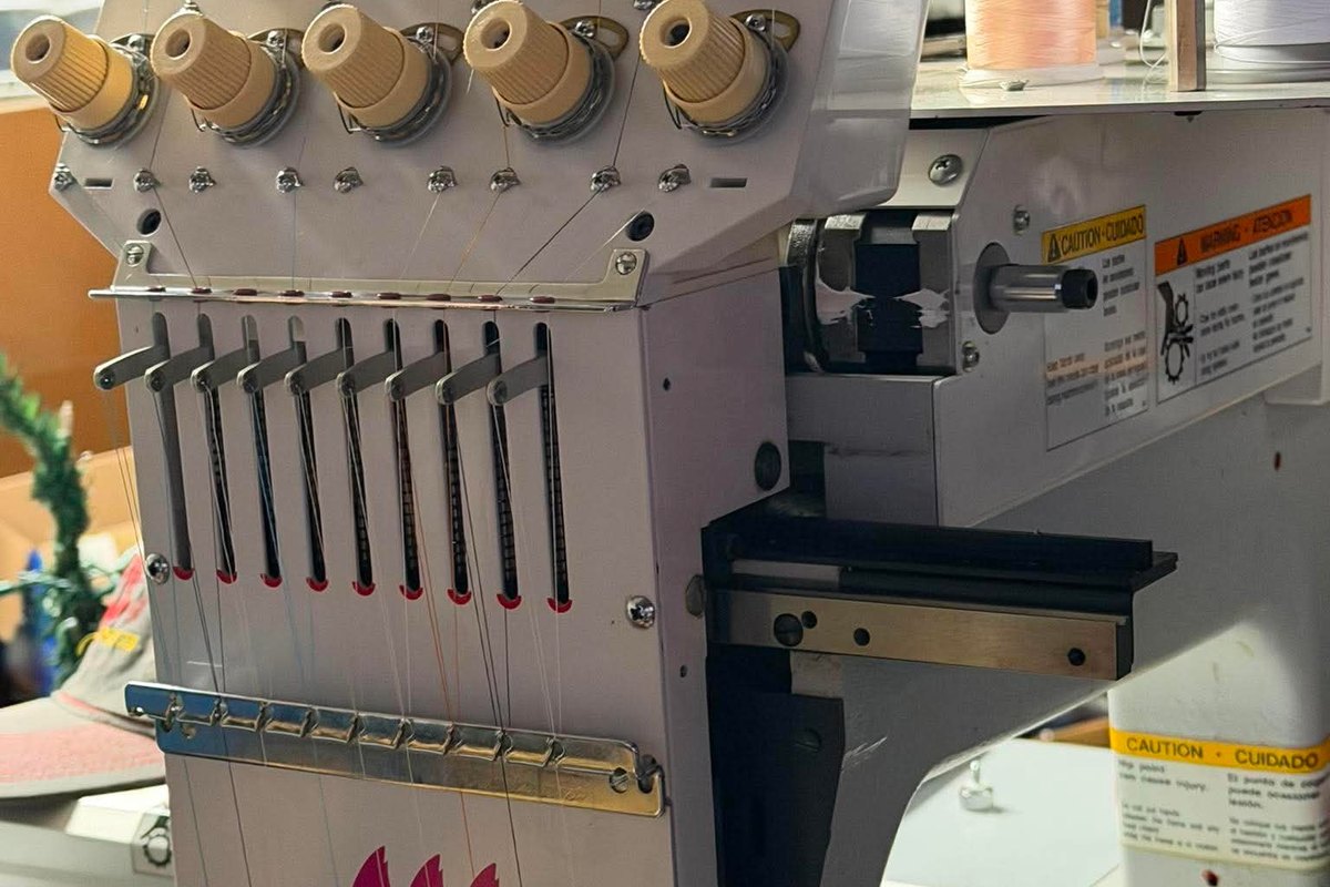 Sewing head showing its tension knobs and upper thread path