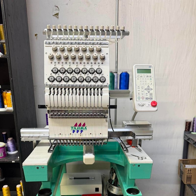 Tajima single-head with an LCD control panel between thread shelves