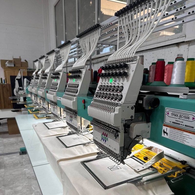 Six-head Tajima embroidery machine stitching canvas tote bags, one hooped under each head