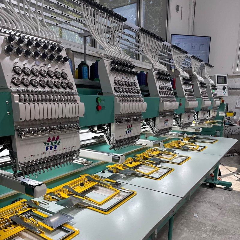 Six-head Tajima embroidery machine with yellow clamp frames laid under every head